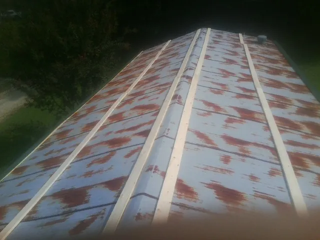 Rusted metal roof panels with new wood purlins before replacement — Storm Damage Roof Repair in Phippsburg by Roofing Brothers