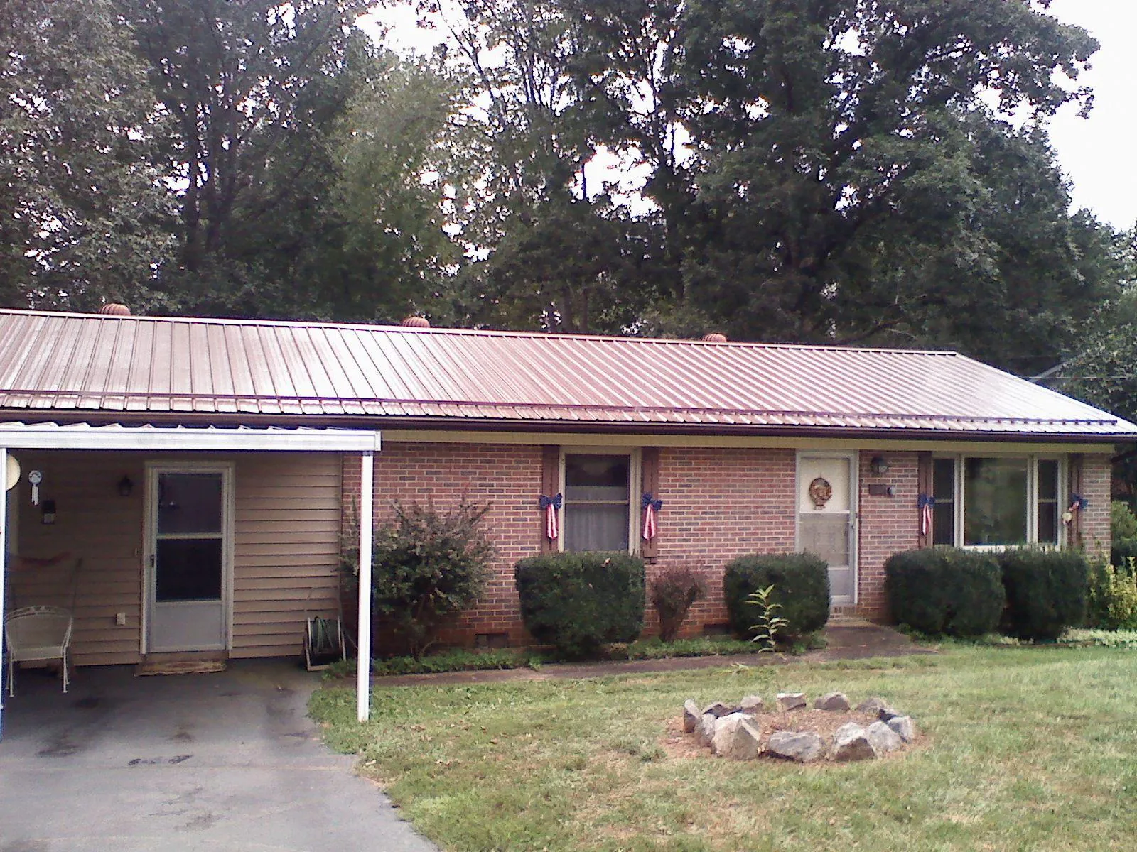 Bronze metal roof and carport on a brick ranch home — Roof Repair work by our crew in Phippsburg